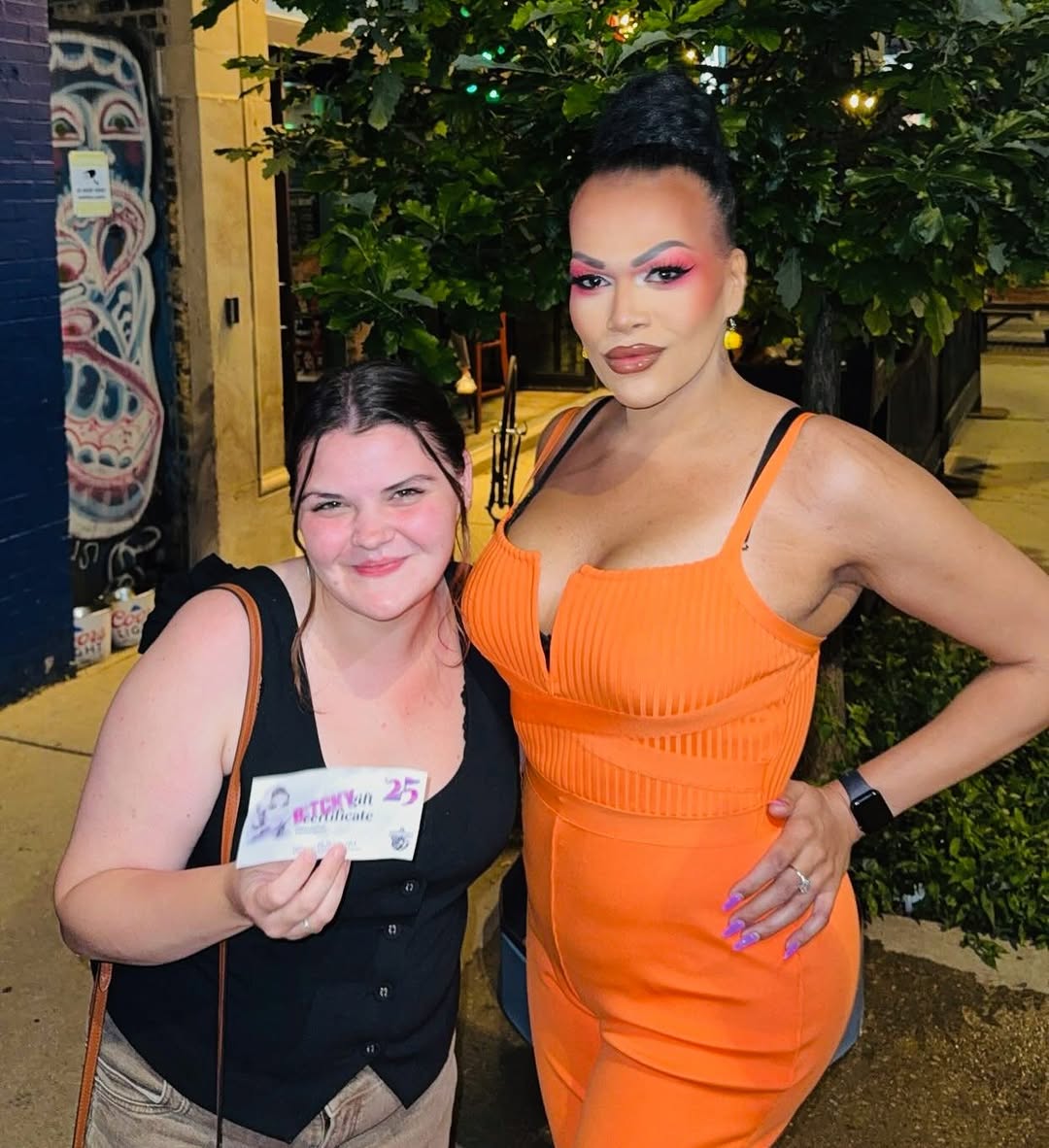 Bitchy Bingo winner holding a $25 gift certificate beside host Batty Davis outside the bar